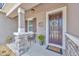 Charming home entrance with a decorative wreath, stone pillar, and a cozy seating area at 12965 Satin Lily Dr, Riverview, FL 33579