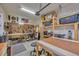 Organized garage and workshop with pegboard, shelving, tools, and work surfaces at 12965 Satin Lily Dr, Riverview, FL 33579