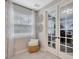Home office showcasing elegant French doors, large window with blinds, and a comfortable basket chair at 12965 Satin Lily Dr, Riverview, FL 33579