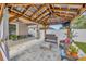 Covered outdoor living area with a wood-framed ceiling, fan, TV, and comfortable seating for relaxing at 12965 Satin Lily Dr, Riverview, FL 33579
