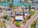 Aerial view of a single-story blue home in a waterfront community, offering a tranquil coastal lifestyle at 13098 Boca Ciega Ave, Madeira Beach, FL 33708
