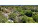 The aerial view shows the home's lush surroundings and a glimpse of the peaceful neighborhood beyond the trees at 1444 Oak Haven Dr, Safety Harbor, FL 34695