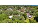 The home sits amid mature trees in a serene neighborhood, as captured from above, with a pool in the distance at 1444 Oak Haven Dr, Safety Harbor, FL 34695