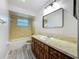 Bathroom features a tub/shower, wood-style vanity, and decorative mirror at 1444 Oak Haven Dr, Safety Harbor, FL 34695