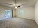 Serene bedroom with plush carpet, a sliding glass door to screened porch, and modern ceiling fan at 1444 Oak Haven Dr, Safety Harbor, FL 34695