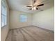 Bright bedroom featuring plush carpet, natural light, and a modern ceiling fan at 1444 Oak Haven Dr, Safety Harbor, FL 34695