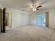 Bright bedroom with ceiling fan, double closets, and access to a sunroom at 1444 Oak Haven Dr, Safety Harbor, FL 34695