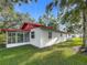 The exterior of a charming home is surrounded by a beautiful green lawn and mature trees at 1444 Oak Haven Dr, Safety Harbor, FL 34695