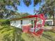 A single-story home with red brick accents, a red roof, well-maintained landscaping and a manicured lawn at 1444 Oak Haven Dr, Safety Harbor, FL 34695