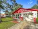 Front exterior of single-story home with red roof and brick accents, with an attached garage and mature landscaping at 1444 Oak Haven Dr, Safety Harbor, FL 34695