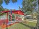 Single-story home featuring a red roof, brick accents, well-maintained landscaping and an American flag at 1444 Oak Haven Dr, Safety Harbor, FL 34695
