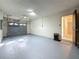 View of the garage with a gray floor and garage door, plus a door to the house interior at 1444 Oak Haven Dr, Safety Harbor, FL 34695