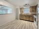 Sunlit kitchen with stainless steel sink and sleek appliances, complete with wood-look flooring at 1444 Oak Haven Dr, Safety Harbor, FL 34695