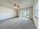 Inviting living room with neutral carpet, ceiling fan, and a large bay window for natural light and viewing at 1444 Oak Haven Dr, Safety Harbor, FL 34695