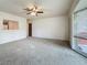 Cozy living room featuring neutral carpet, a ceiling fan, and a pass-through to the kitchen at 1444 Oak Haven Dr, Safety Harbor, FL 34695