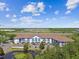 Aerial view of complex with pond and blue buildings on sunny day at 1610 Raena Dr # 204, Odessa, FL 33556