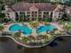 Aerial shot of a pool and condo complex surrounded by lush trees and greenery at 1610 Raena Dr # 204, Odessa, FL 33556