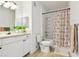 Bright bathroom featuring a shower-tub combo, white vanity with sink, and patterned shower curtain at 1610 Raena Dr # 204, Odessa, FL 33556