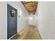 Hallway with wooden floors, a blue door with an Easter basket, and white textured walls at 1610 Raena Dr # 204, Odessa, FL 33556