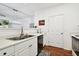 Well-lit kitchen featuring white cabinets, laminate countertops, a stainless sink, and appliances at 1610 Raena Dr # 204, Odessa, FL 33556