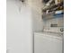 Laundry area with a white washing machine, wire shelving for storage, and white walls at 1610 Raena Dr # 204, Odessa, FL 33556