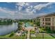 Scenic view of a community pool, lake, and surrounding buildings showcasing the outdoor amenities at 1610 Raena Dr # 204, Odessa, FL 33556