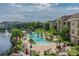 Overhead shot of a large community pool with lush landscaping, water feature, and seating areas at 1610 Raena Dr # 204, Odessa, FL 33556