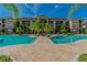 Exterior view of the community pool surrounded by palm trees and lush landscaping on a sunny day at 1610 Raena Dr # 204, Odessa, FL 33556