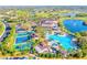 Stunning aerial view of a community with pools, tennis courts, and lush landscaping by a lake at 201 Kings Blvd # 19, Sun City Center, FL 33573
