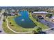 Scenic aerial view of a community with a central lake featuring a fountain and well-maintained surroundings at 201 Kings Blvd # 19, Sun City Center, FL 33573