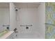 Bright bathroom features a tiled shower and tub with a unique accent wall at 201 Kings Blvd # 19, Sun City Center, FL 33573
