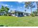 A well-maintained backyard showing a screened in patio, a sprawling lawn and community view at 201 Kings Blvd # 19, Sun City Center, FL 33573