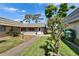 Attractive single-story home with a neatly manicured lawn and walkway creates a welcoming entry at 201 Kings Blvd # 19, Sun City Center, FL 33573