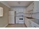 Cozy kitchen with classic white cabinetry, appliances, and tile flooring at 201 Kings Blvd # 19, Sun City Center, FL 33573