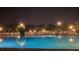 Nighttime view of a well-lit pool area with lounge chairs and umbrellas, creating a relaxing ambiance at 201 Kings Blvd # 19, Sun City Center, FL 33573