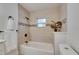 Clean bathroom with tiled walls, plant accent, and a bathtub with shower at 2920 N 11Th St, Tampa, FL 33605