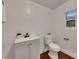 Bright bathroom featuring a modern gray vanity and toilet complemented by wood-look flooring and neutral decor at 2920 N 11Th St, Tampa, FL 33605