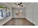 Cozy bedroom featuring two windows with tree views, white walls, and a ceiling fan at 2920 N 11Th St, Tampa, FL 33605