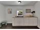 Charming wet bar featuring white cabinets, dark sink, and neutral countertop with artwork adorning the walls at 2920 N 11Th St, Tampa, FL 33605