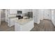 Modern kitchen with stainless steel appliances, granite countertops, an island, and wood flooring at 29535 Fedora Cir, Brooksville, FL 34602