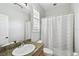Neutral bathroom features a white tub with shower, toilet, and single granite vanity at 3025 W Grovewood Ct # B, Tampa, FL 33629