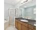 Bathroom featuring granite counters, a glass enclosed shower, and large soaking tub at 3025 W Grovewood Ct # B, Tampa, FL 33629