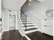 Bright foyer with hardwood floors, staircase with wrought iron railing, and white wainscoting at 3025 W Grovewood Ct # B, Tampa, FL 33629