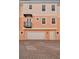 Three-story townhome with a two-car garage, balcony, and charming peach-colored facade at 3025 W Grovewood Ct # B, Tampa, FL 33629