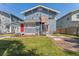 Backyard view of the house with grass, brick trim, an outdoor staircase, and red doors at 307 S Newport Ave, Tampa, FL 33606