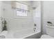 Bright bathroom featuring a white tiled bathtub, window, and modern fixtures at 307 S Newport Ave, Tampa, FL 33606