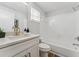 Bright bathroom featuring a white vanity with a quartz countertop, gold fixtures and tiled shower at 307 S Newport Ave, Tampa, FL 33606