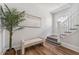 Bright entryway with hardwood floors, bench seating, stairway, and decorative wall art at 307 S Newport Ave, Tampa, FL 33606
