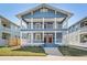 Charming blue two-story home featuring double porches, white columns, and lush green lawn at 307 S Newport Ave, Tampa, FL 33606