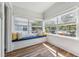 Cozy sunroom featuring hardwood floors, large windows with backyard views, and a window seat at 307 S Newport Ave, Tampa, FL 33606